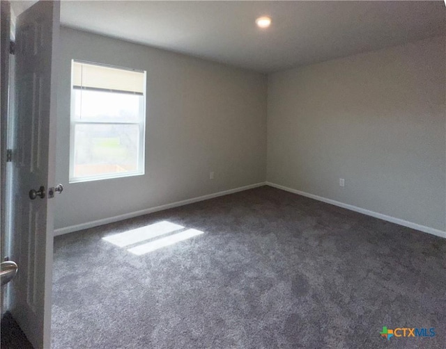 carpeted spare room with baseboards