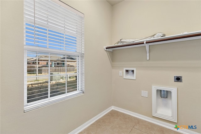 clothes washing area with hookup for an electric dryer, hookup for a washing machine, and light tile patterned flooring