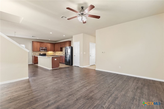 kitchen with refrigerator with ice dispenser, dark wood-type flooring, hanging light fixtures, ceiling fan, and a kitchen island