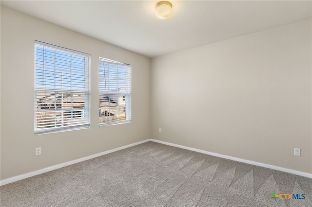 carpeted spare room featuring a healthy amount of sunlight