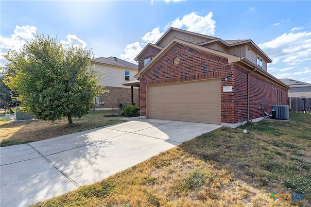 view of front of home with a garage, central AC, and a front yard