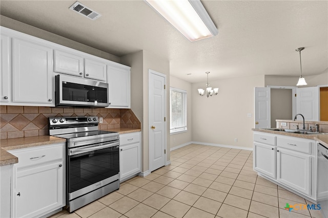 2207 Merle Dr, Copperas Cove, TX 76522 - kitchen featuring stainless steel appliances, a chandelier, decorative backsplash, white cabinetry, and hanging light fixtures
