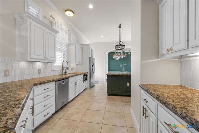 kitchen with sink, stainless steel appliances, light tile patterned floors, dark stone countertops, and white cabinets