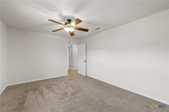 empty room with light colored carpet, visible vents, ceiling fan, and baseboards