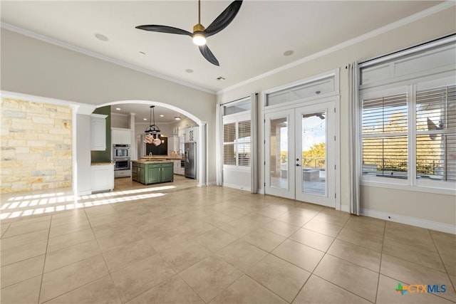 interior space with ceiling fan, light tile patterned floors, crown molding, and french doors