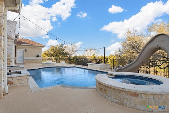 view of swimming pool with an in ground hot tub and a water slide