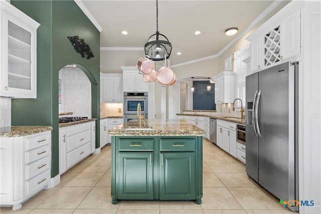 kitchen with white cabinets, an island with sink, glass insert cabinets, stainless steel appliances, and green cabinets