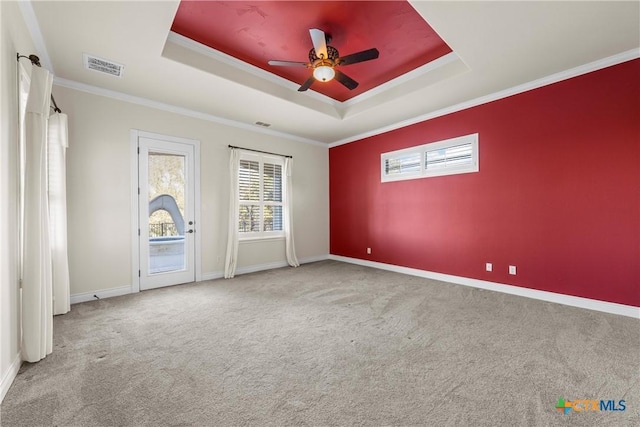 carpeted empty room with a raised ceiling, crown molding, and ceiling fan