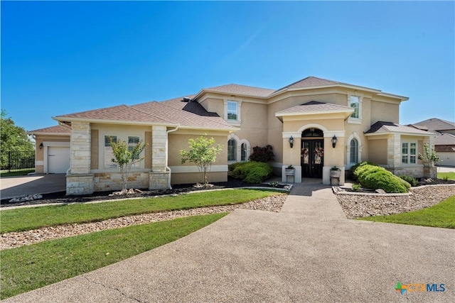 9864 Sendera Dr, Belton, TX 76513 - mediterranean / spanish home featuring a garage, stucco siding, stone siding, a shingled roof, and driveway