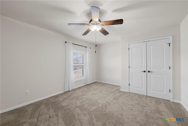 unfurnished bedroom with light carpet, a ceiling fan, baseboards, and a closet