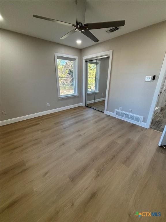 unfurnished bedroom featuring ceiling fan, a closet, and light hardwood / wood-style flooring