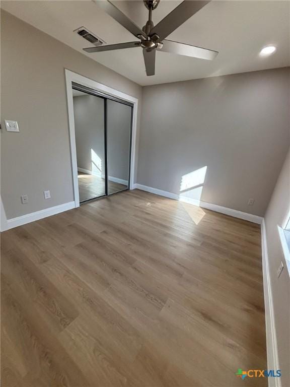 unfurnished bedroom with ceiling fan, a closet, and light hardwood / wood-style flooring