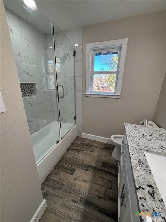 full bathroom with enclosed tub / shower combo, toilet, and vanity