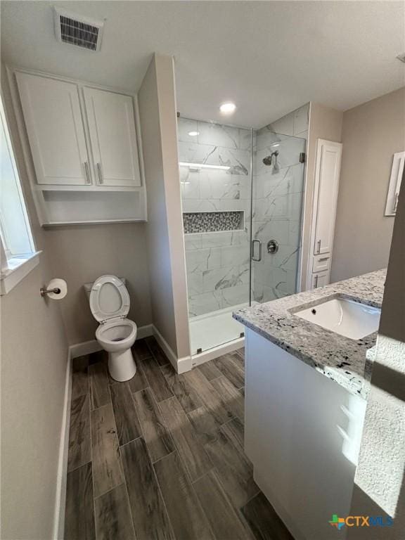 bathroom with toilet, walk in shower, and vanity