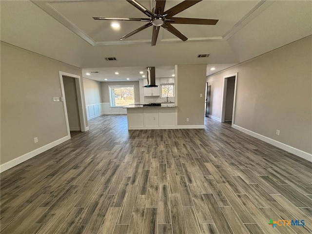 unfurnished living room with ceiling fan, a tray ceiling, and hardwood / wood-style floors