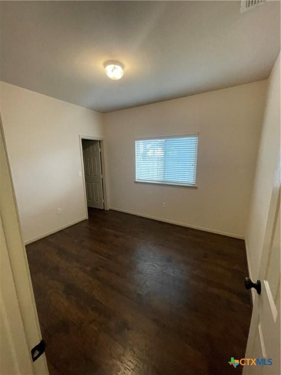 spare room with dark hardwood / wood-style flooring