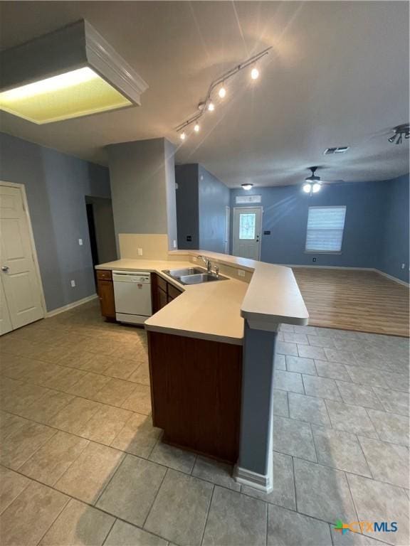 kitchen with kitchen peninsula, sink, light tile patterned floors, ceiling fan, and white dishwasher