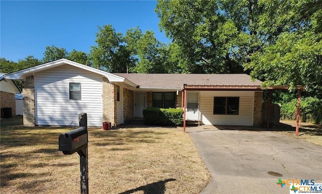 ranch-style house featuring brick siding, central AC unit, a front lawn, and driveway
