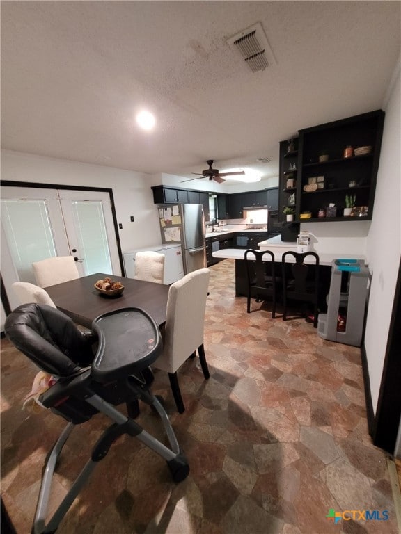dining space with visible vents, a ceiling fan, and stone finish floor
