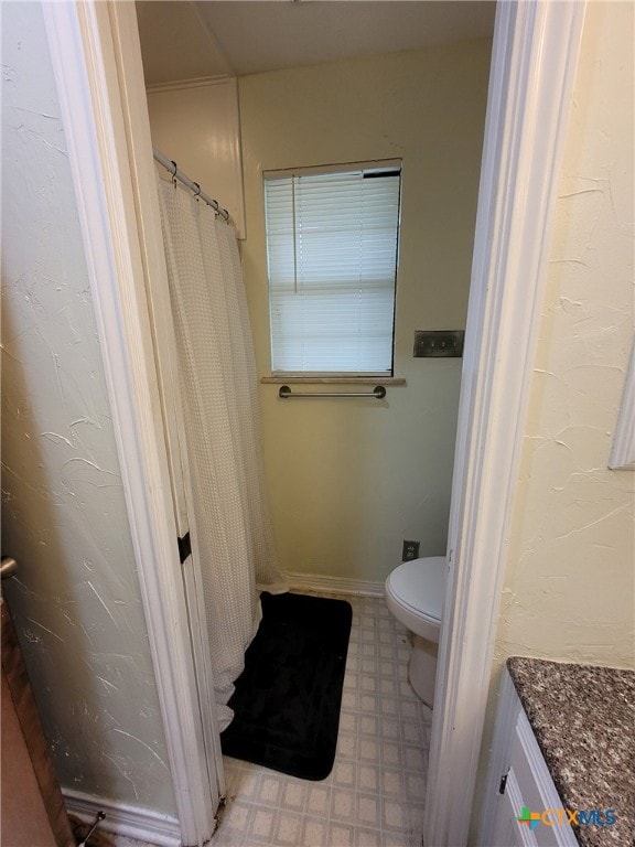 full bath with tile patterned floors and toilet