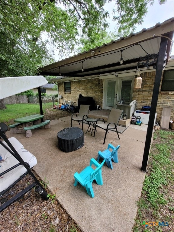 view of patio with fence and a fire pit