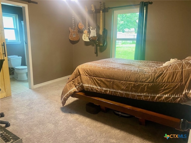 carpeted bedroom with baseboards and ensuite bathroom