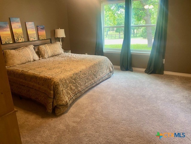 bedroom featuring carpet and baseboards