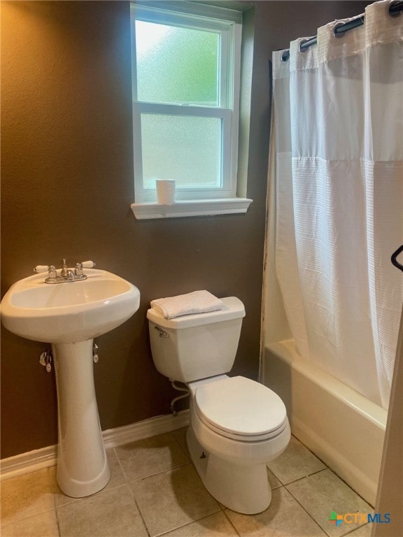 full bath with tile patterned flooring, toilet, a sink, baseboards, and shower / bathtub combination with curtain