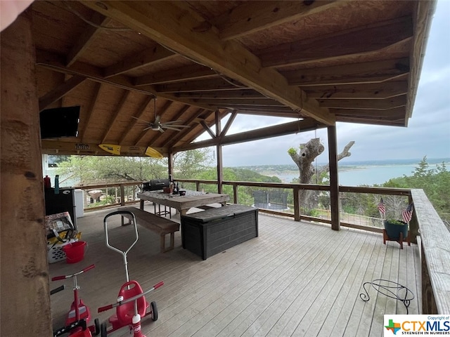 wooden deck with a water and mountain view and ceiling fan