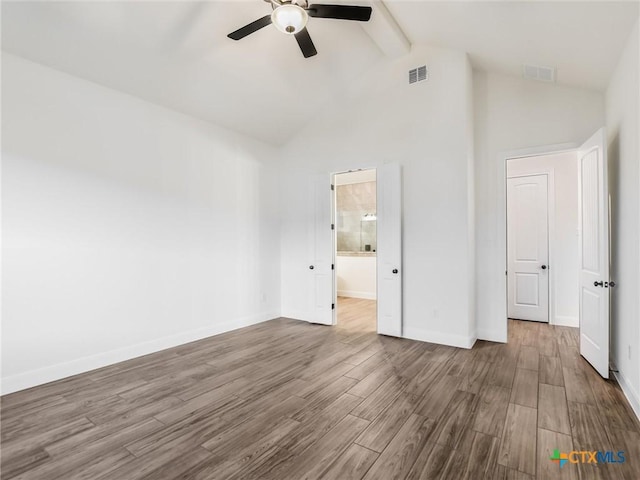 unfurnished bedroom with ceiling fan, beam ceiling, wood-type flooring, connected bathroom, and high vaulted ceiling