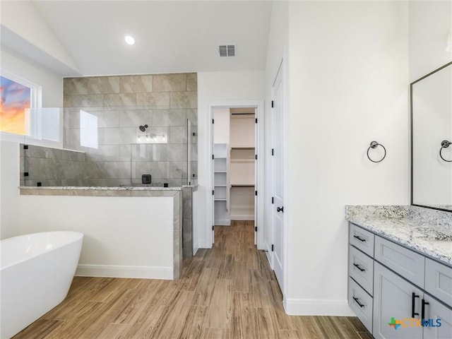 bathroom featuring separate shower and tub, lofted ceiling, hardwood / wood-style floors, and vanity