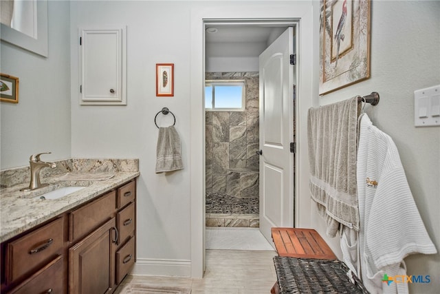 bathroom with vanity and a tile shower