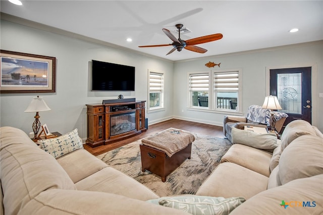 living room with hardwood / wood-style floors, ceiling fan, and crown molding