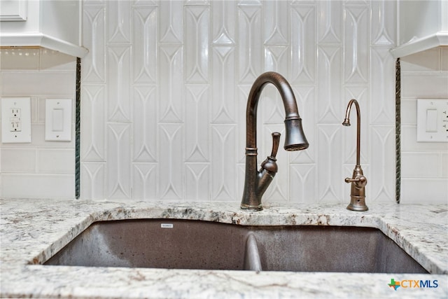 interior details featuring sink and light stone counters