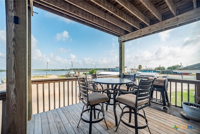 wooden terrace with a water view and a pool