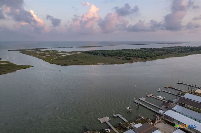 aerial view at dusk featuring a water view