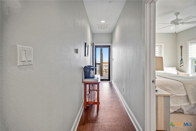 hallway with dark hardwood / wood-style flooring and a wealth of natural light