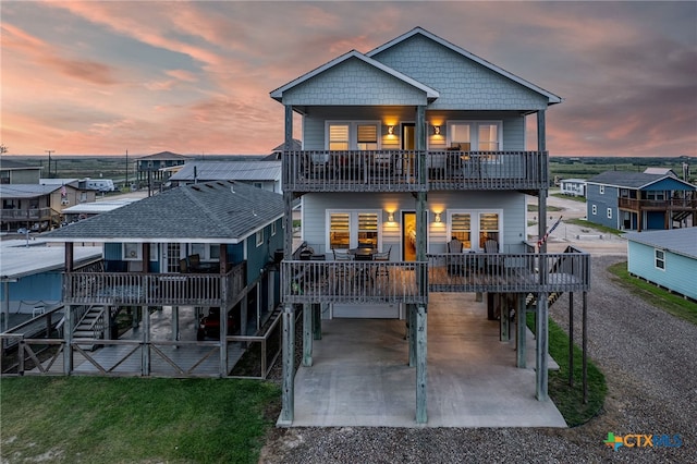 back house at dusk featuring a deck and a carport