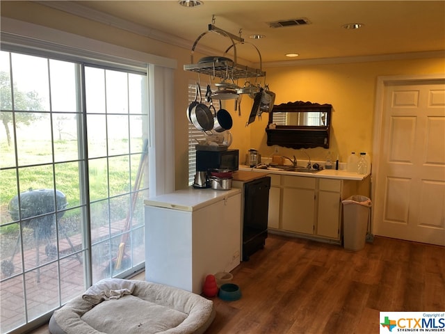 kitchen with black appliances, dark hardwood / wood-style flooring, sink, and crown molding