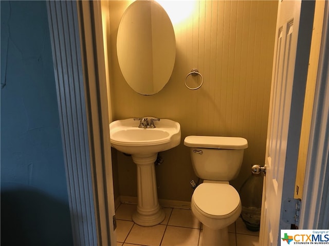 bathroom featuring tile patterned floors, toilet, and wooden walls