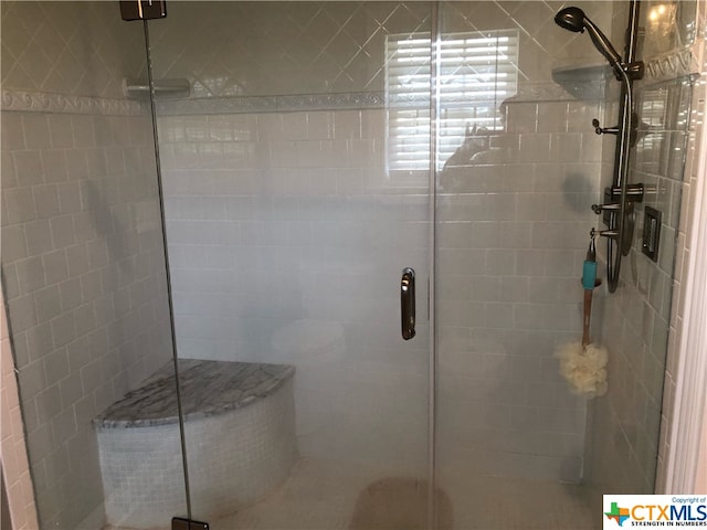 bathroom with a shower with door