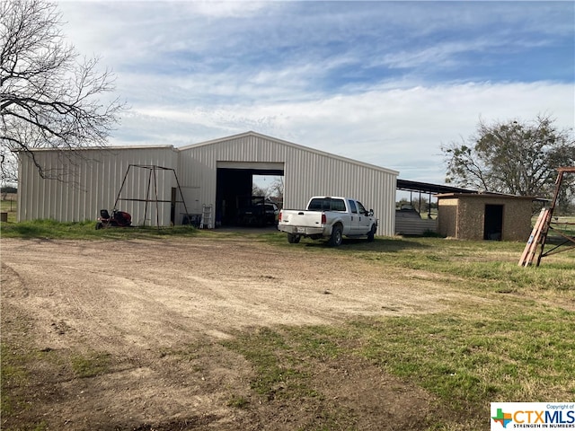 view of outdoor structure featuring a garage and a carport