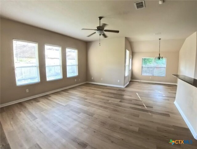 8710 Jogeva Way, San Antonio, TX 78251 - unfurnished living room featuring ceiling fan, wood finished floors, baseboards, and a chandelier