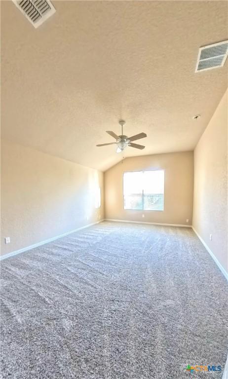 8710 Jogeva Way, San Antonio, TX 78251 - carpeted empty room featuring a ceiling fan, baseboards, lofted ceiling, and a textured ceiling