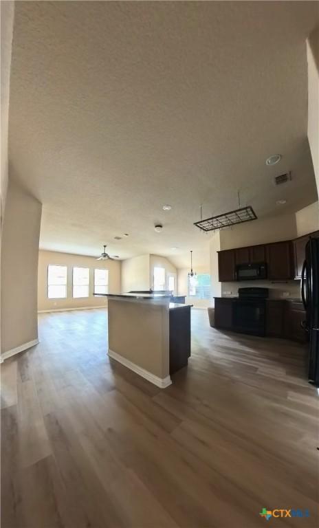 8710 Jogeva Way, San Antonio, TX 78251 - kitchen featuring black appliances, open floor plan, wood finished floors, dark brown cabinetry, and recessed lighting