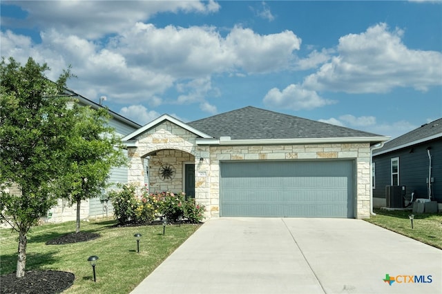305 Stone Water Ln, Jarrell, TX 76537 - french country home featuring a front lawn, concrete driveway, an attached garage, stone siding, and roof with shingles