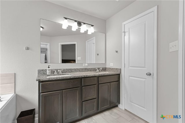 7005 Mcgregor Loop, Killeen, TX 76549 - full bath with double vanity, a tub to relax in, and wood finished floors
