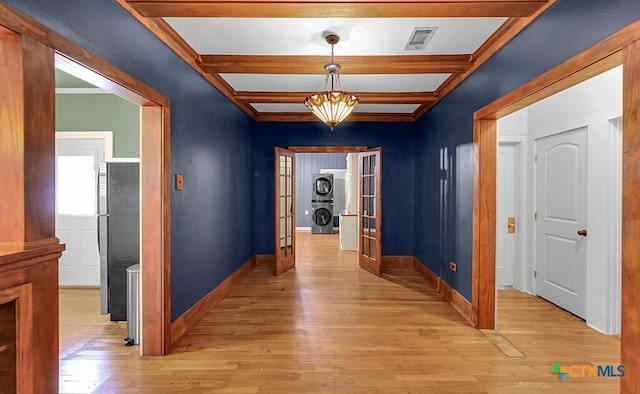 905 N 33rd St, Waco, TX 76707 - hallway featuring stacked washer / dryer, french doors, light wood finished floors, and beamed ceiling
