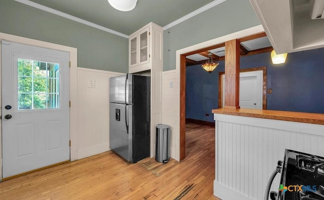 905 N 33rd St, Waco, TX 76707 - kitchen featuring freestanding refrigerator, light wood-style floors, white cabinetry, crown molding, and a chandelier