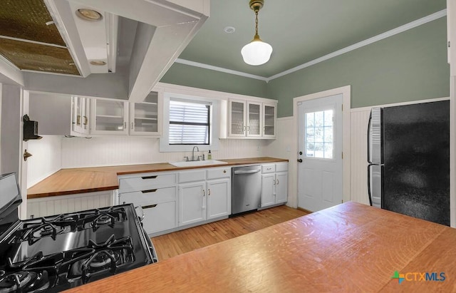 905 N 33rd St, Waco, TX 76707 - kitchen with stainless steel appliances, wood counters, light wood-type flooring, white cabinetry, and crown molding